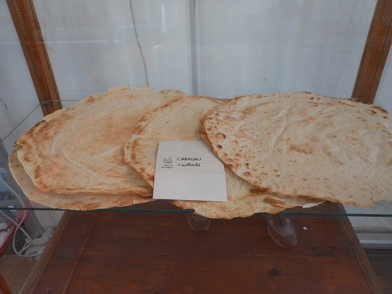 Fogli di pane carasau di Galtellì esposti su un ripiano di vetro